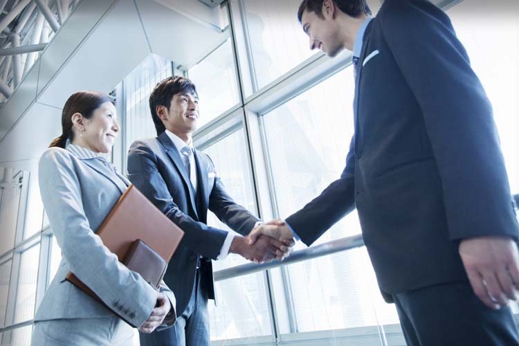 日本のビジネスマンと外国人ビジネスマンが握手