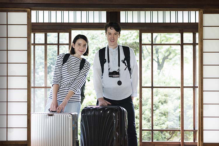 スーツケースを持って旅館を訪れた外国人の若いカップル